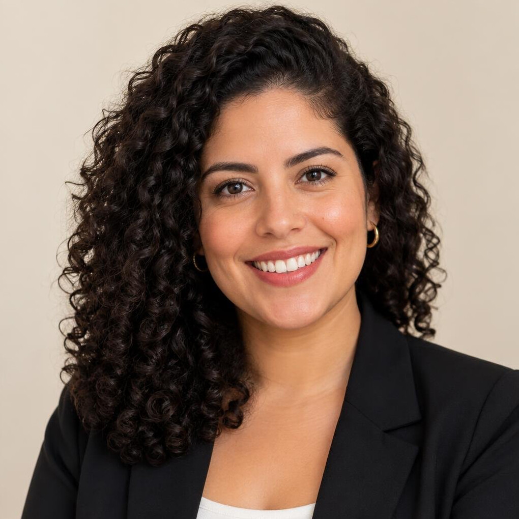 Studio portrait of a Brazilian woman with curly hair smiling
